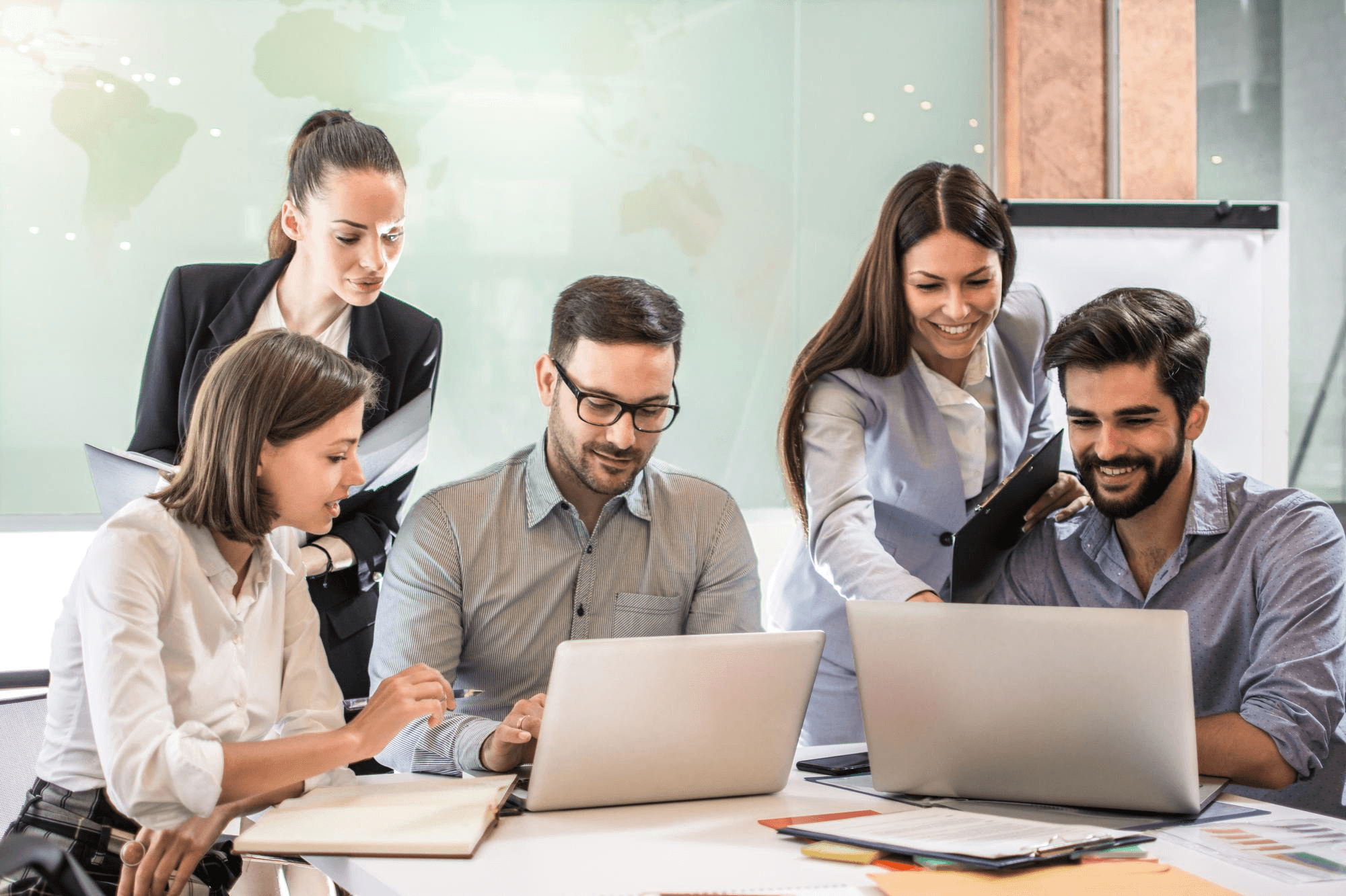 Diverse group of software and telecom engineers collaborating around laptops